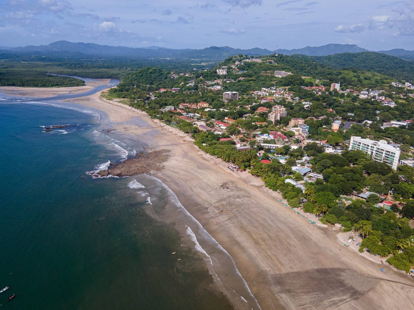 An aerial view of Tamarindo, Costa Rica, showing the beach, the river mouth and the town