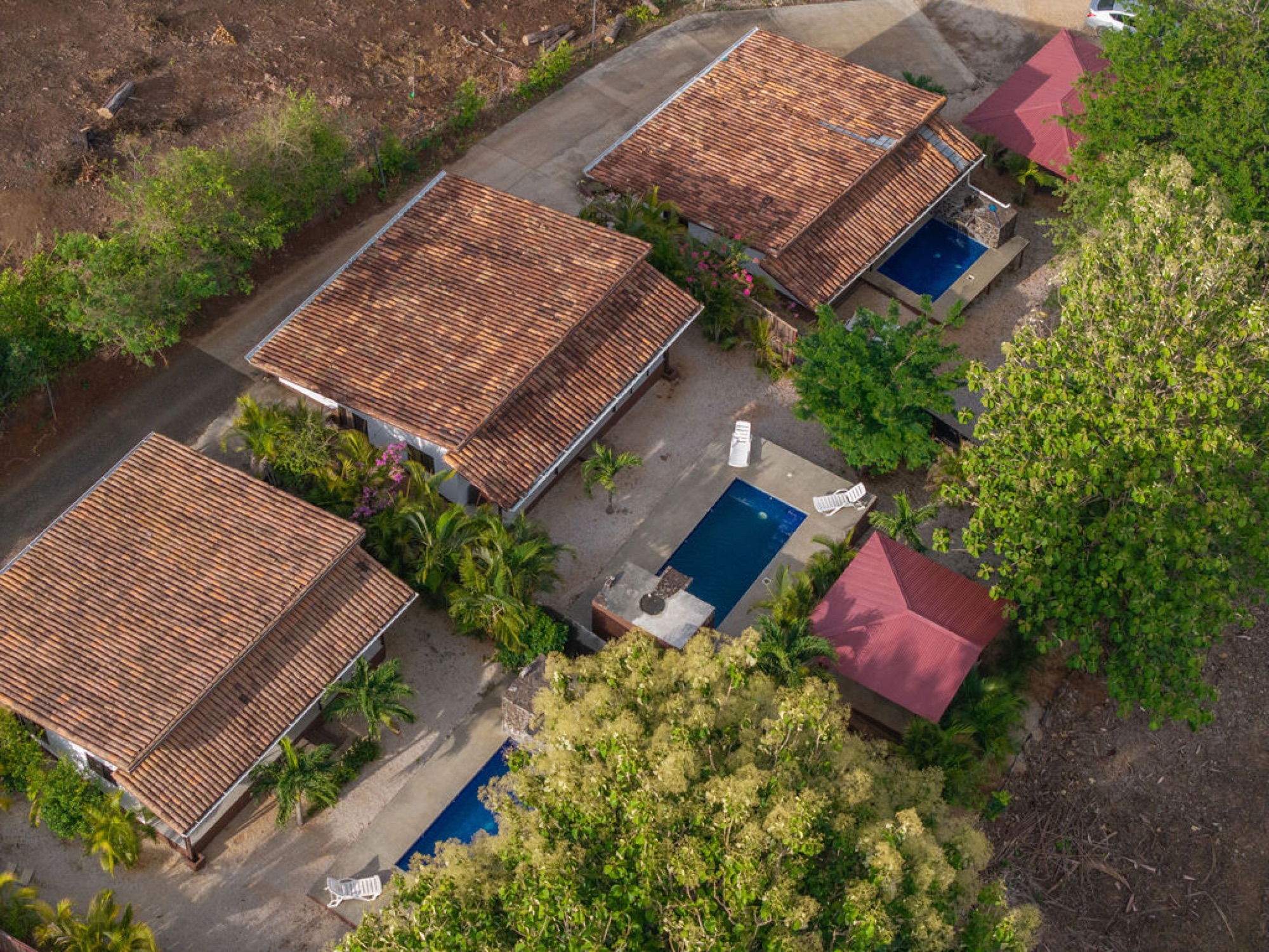 Aerial view of the compound showing tile roofs and private pools