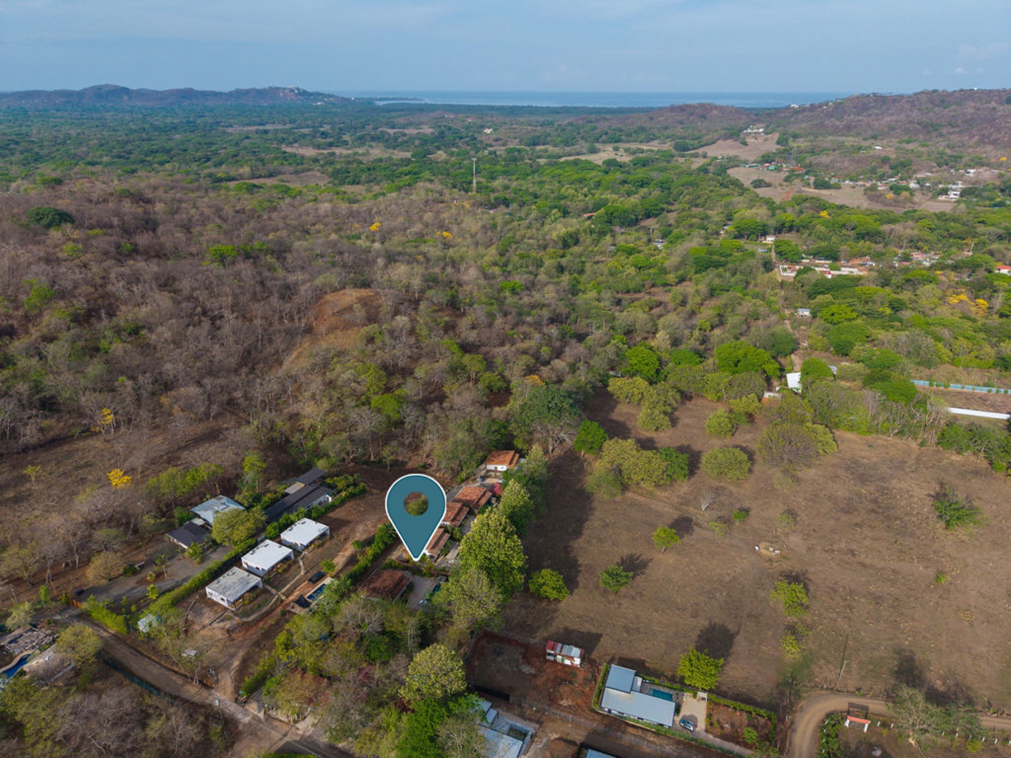 Aerial view showing the property's position between the hills and the coast