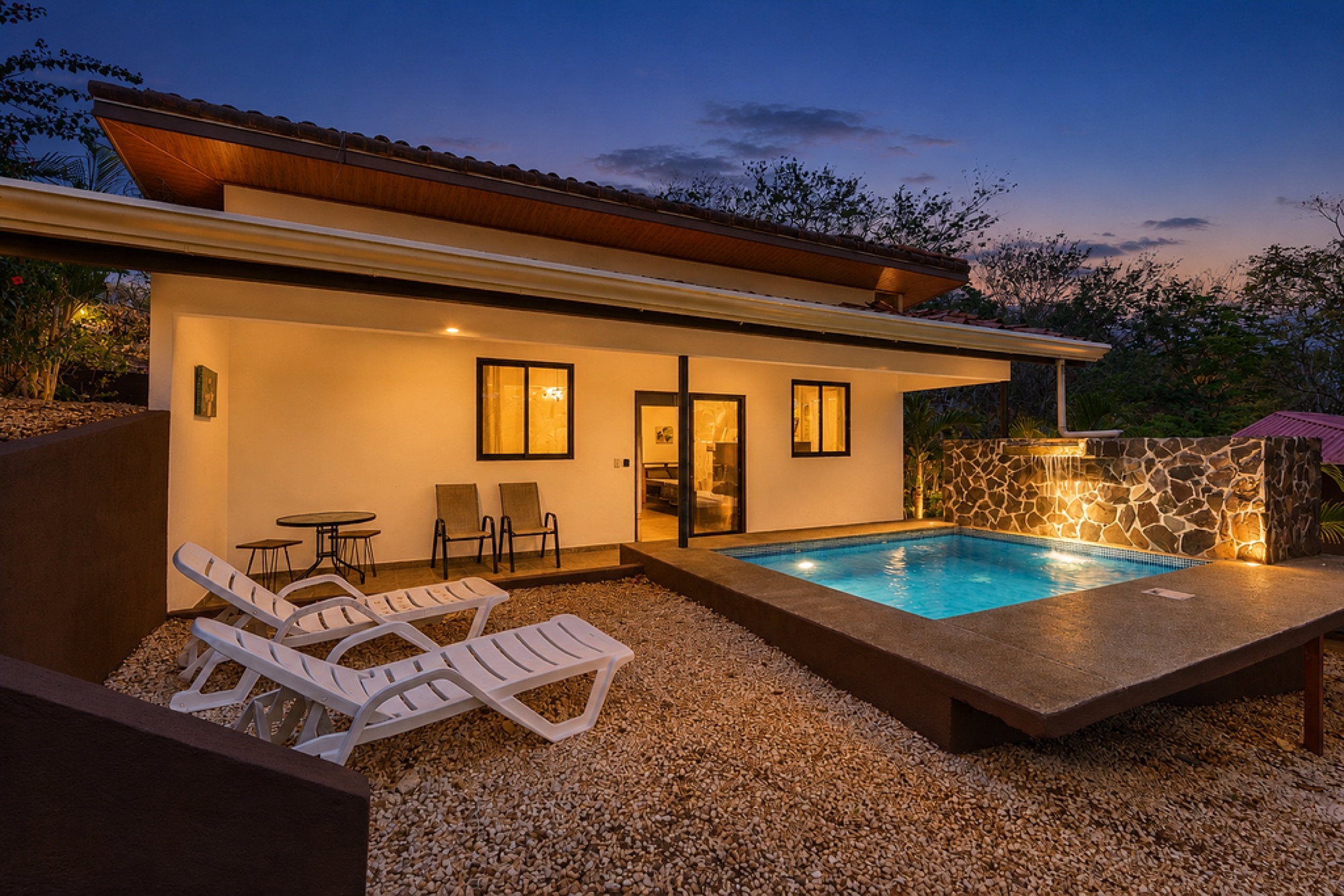 Villa and pool at blue hour with stone water feature