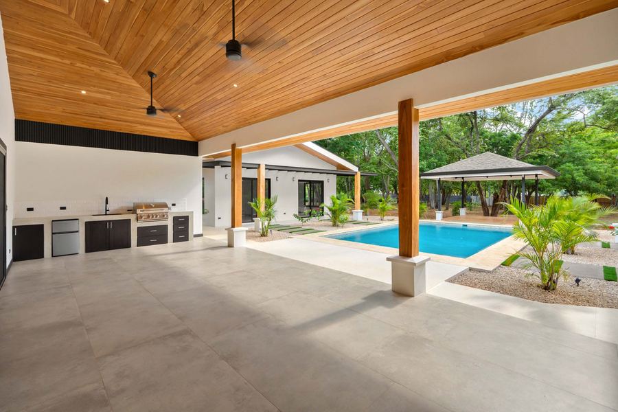 The grand covered terrace with outdoor kitchen, looking to the pool